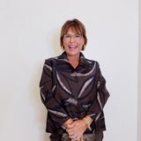 woman wearing a brown nigh out jacket blouse in brown against a white background. 