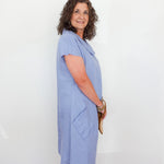 Woman wearing a light blue dress against a white background
