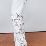 White lace pants worn by a person on a plain background