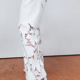 White lace pants worn by a person on a plain background