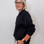 women modeling a black v neck sweatshirt in black. 