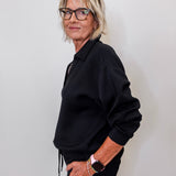 women modeling a black v neck sweatshirt in black. 