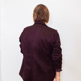 Person wearing a dark brown coat against a white background