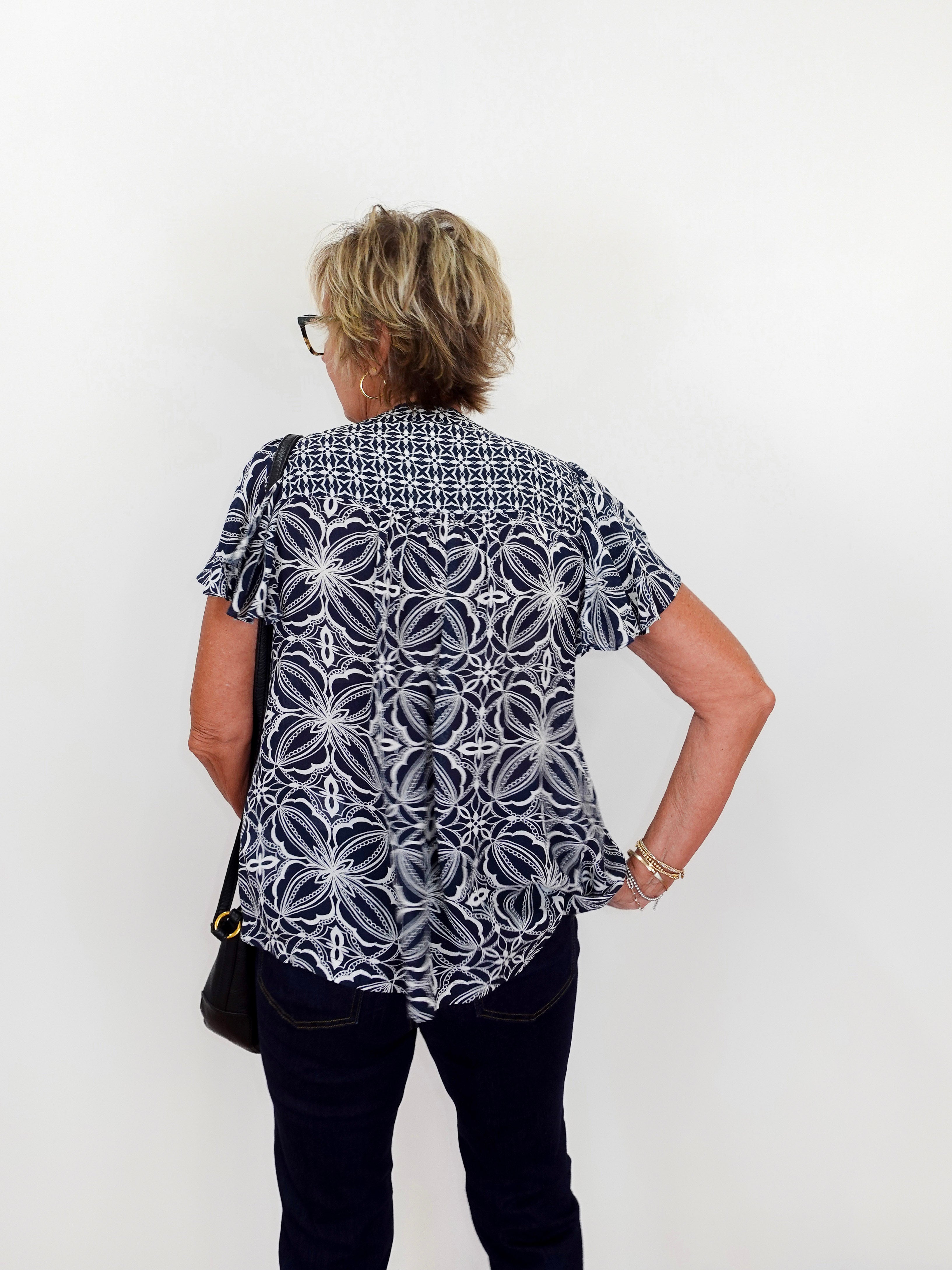 Person wearing a black and white patterned shirt against a white background