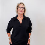 women modeling a black v neck sweatshirt against a white background 