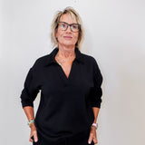 women modeling a black v neck sweatshirt against a white background 