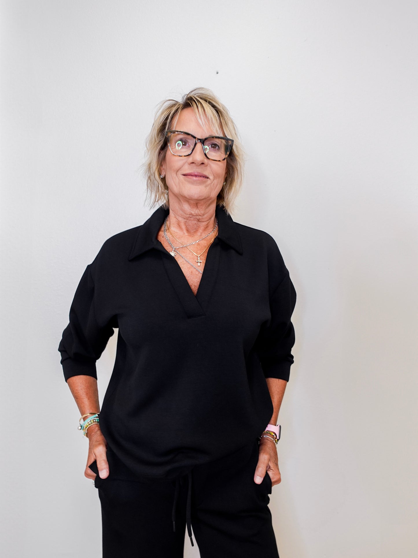 women modeling a black v neck sweatshirt against a white background 