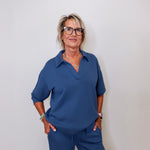 Casual Liverpool pacific blue V-neck sweatshirt with collar worn by woman against white backdrop