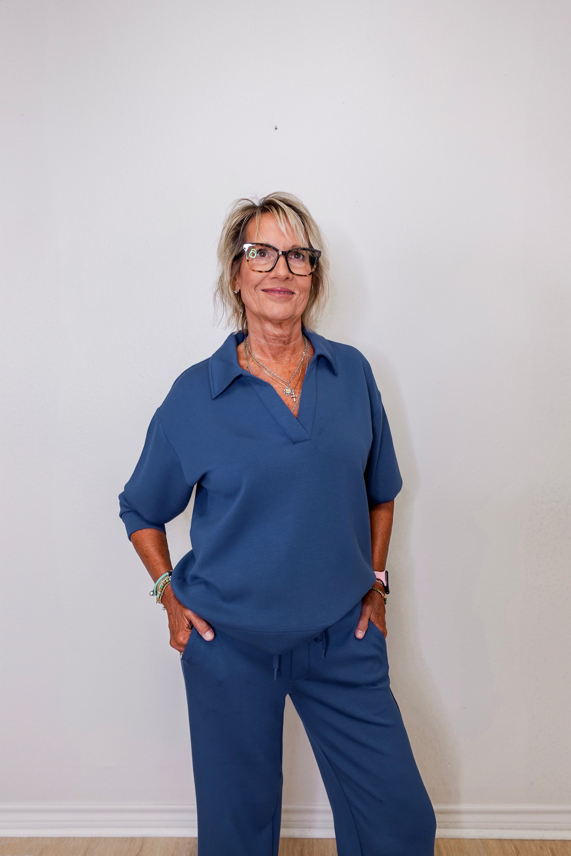 Casual Liverpool pacific blue V-neck sweatshirt with collar worn by woman against white backdrop
