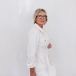 Person wearing a white outfit with a plain background