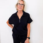 Woman wearing a black outfit against a white background