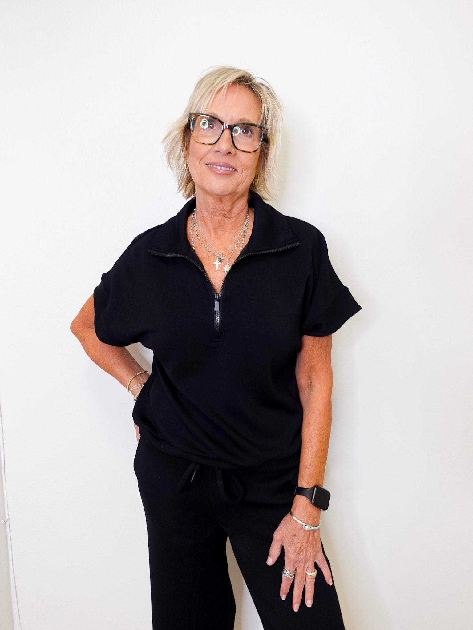 Woman wearing a black outfit against a white background