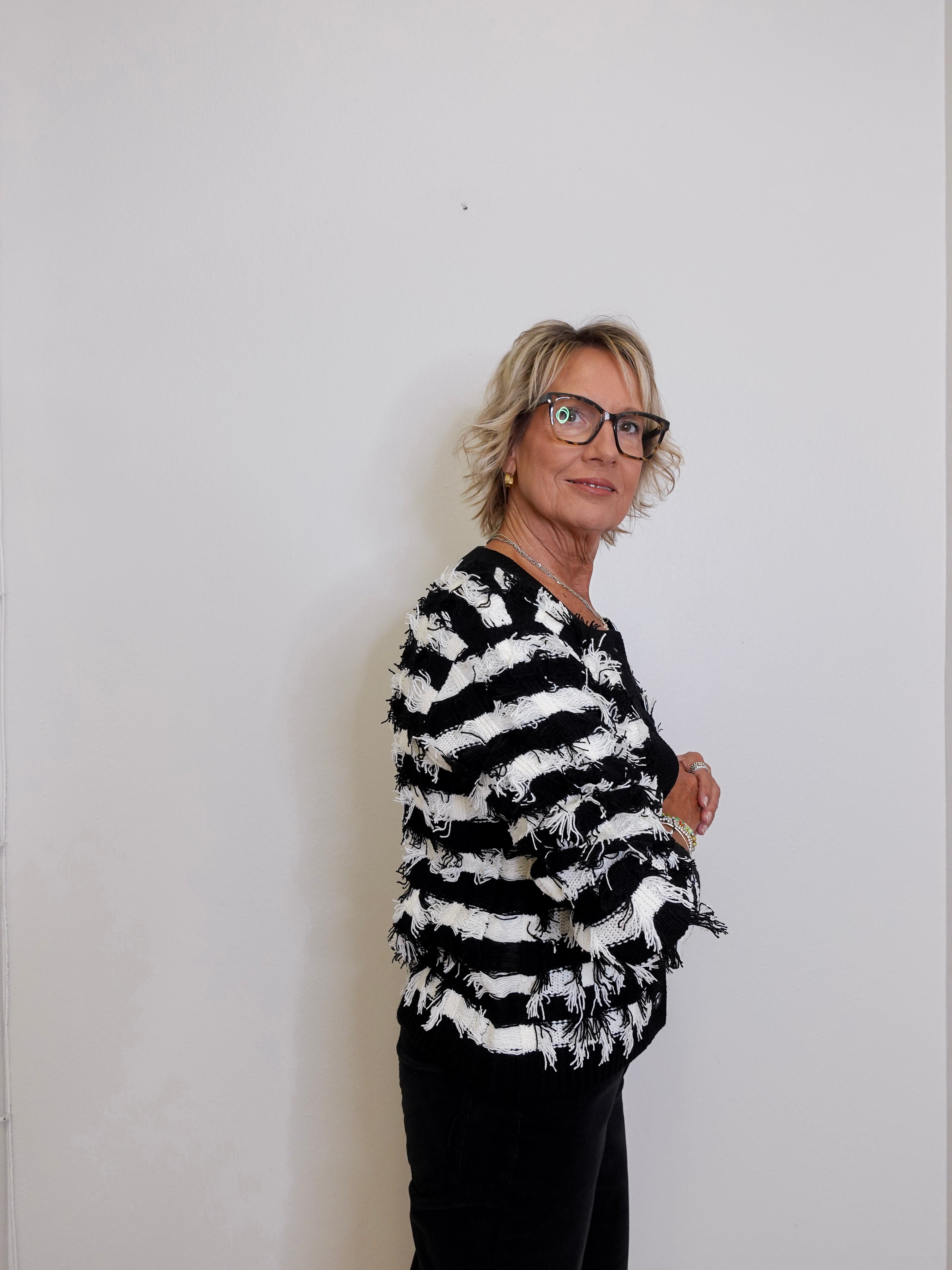 Person wearing a black and white striped shirt against a plain background