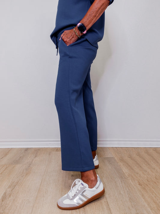 Model showcasing Liverpool pacific blue wide leg crop pull-on pants in front of white wall
