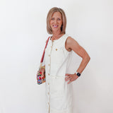Woman in a white dress standing against a white wall