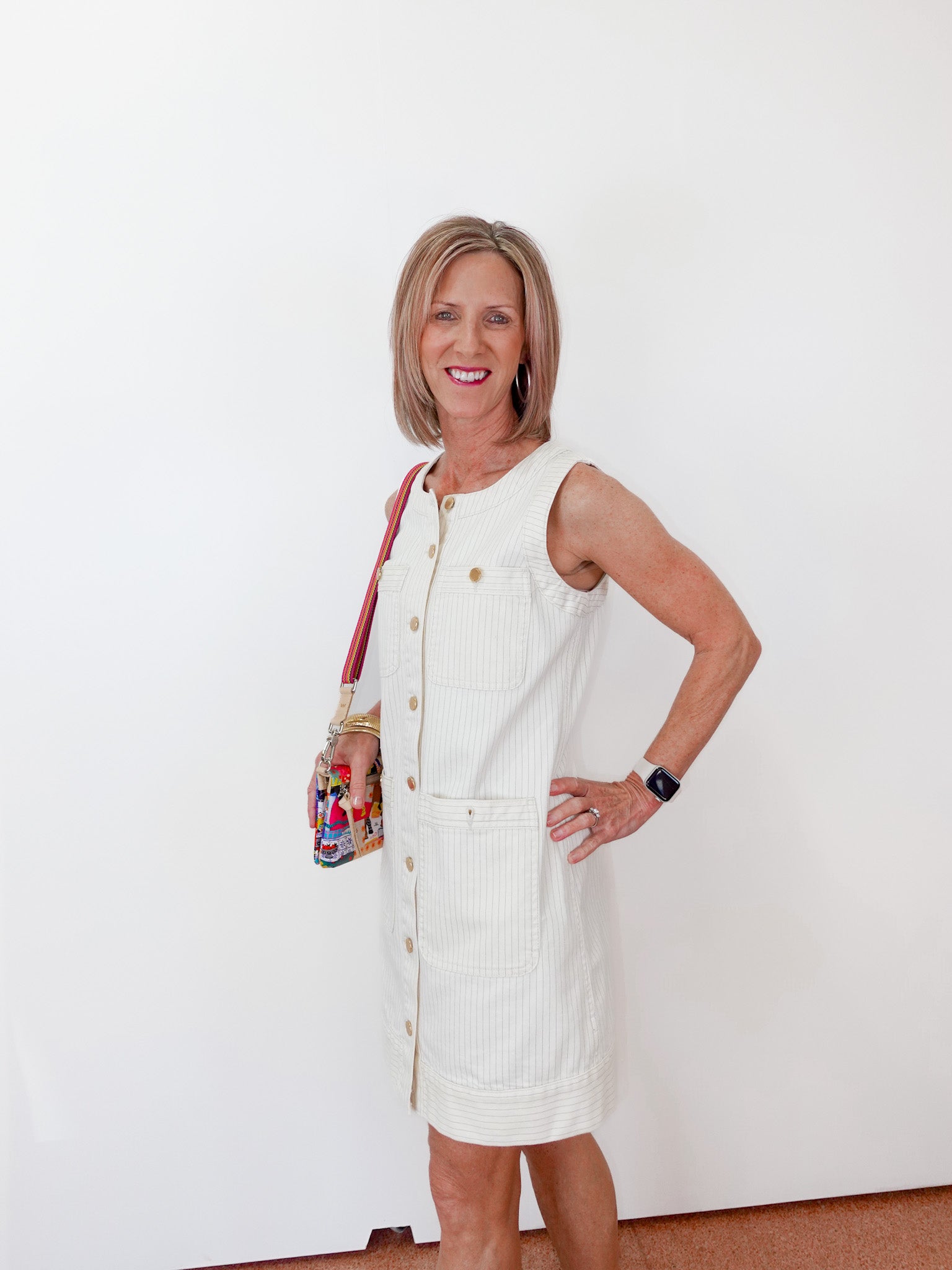 Woman in a white dress standing against a white wall