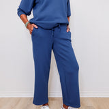 Woman wearing Liverpool pacific blue pull-on wide leg crop pants standing against a white wall