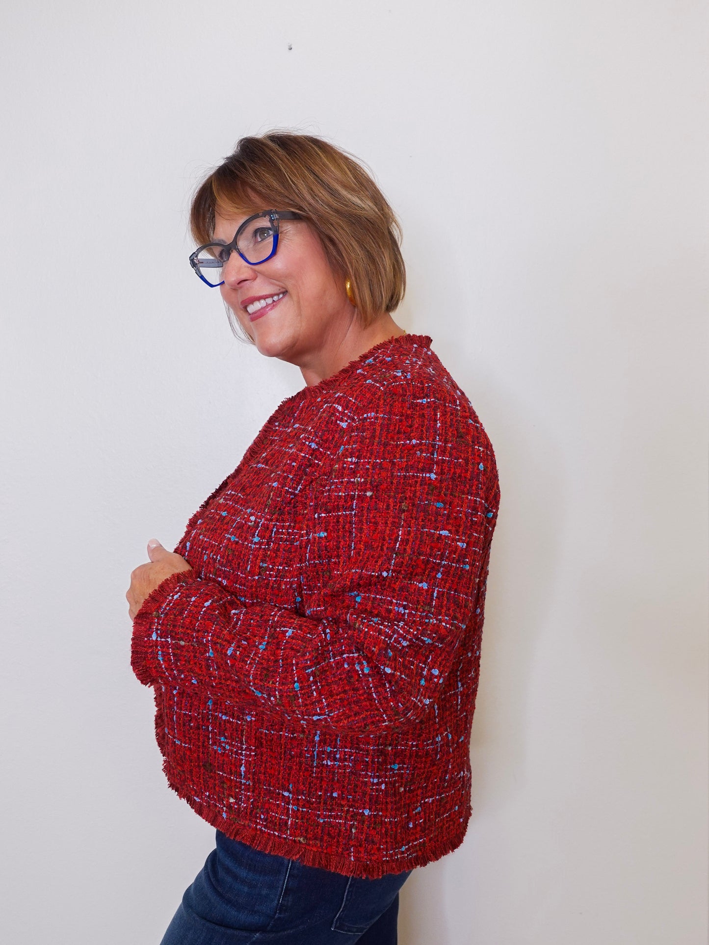Person wearing a red patterned sweater against a white background