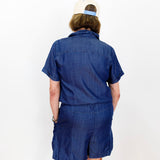 Person wearing a blue outfit with a white cap on a plain background