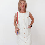 Woman in a white dress holding colorful items against a white background