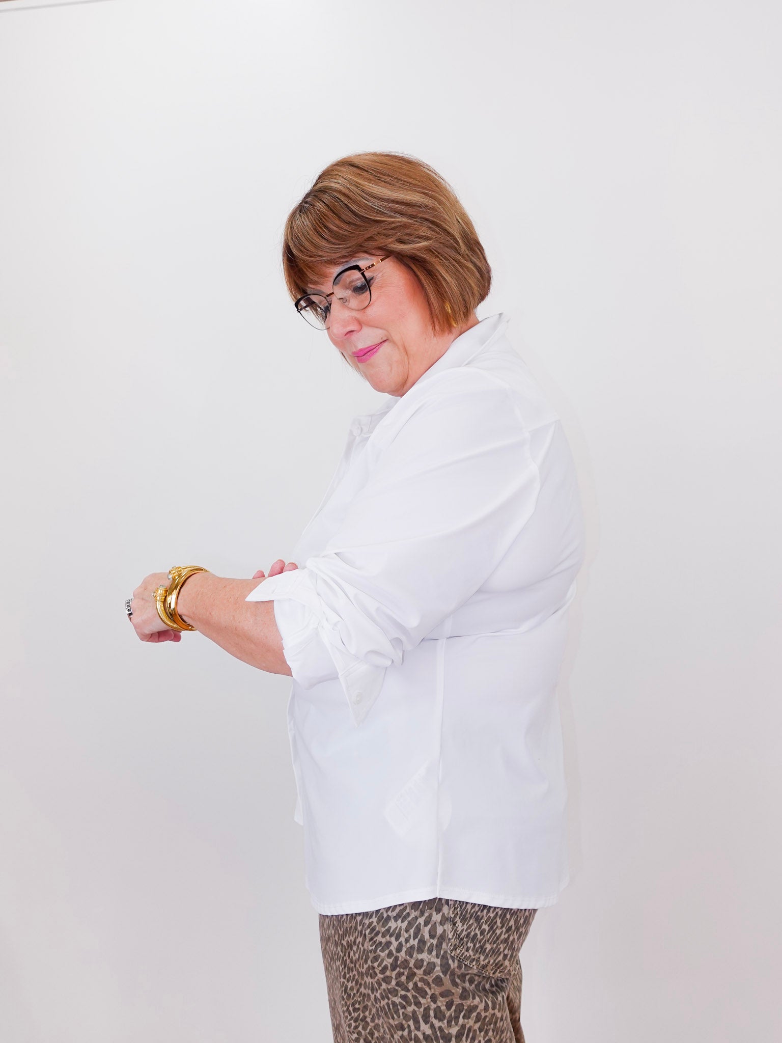 Person wearing a white shirt and leopard print pants against a white background