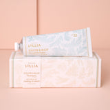 Lollia Snowdrop hand cream packaging on a pink background