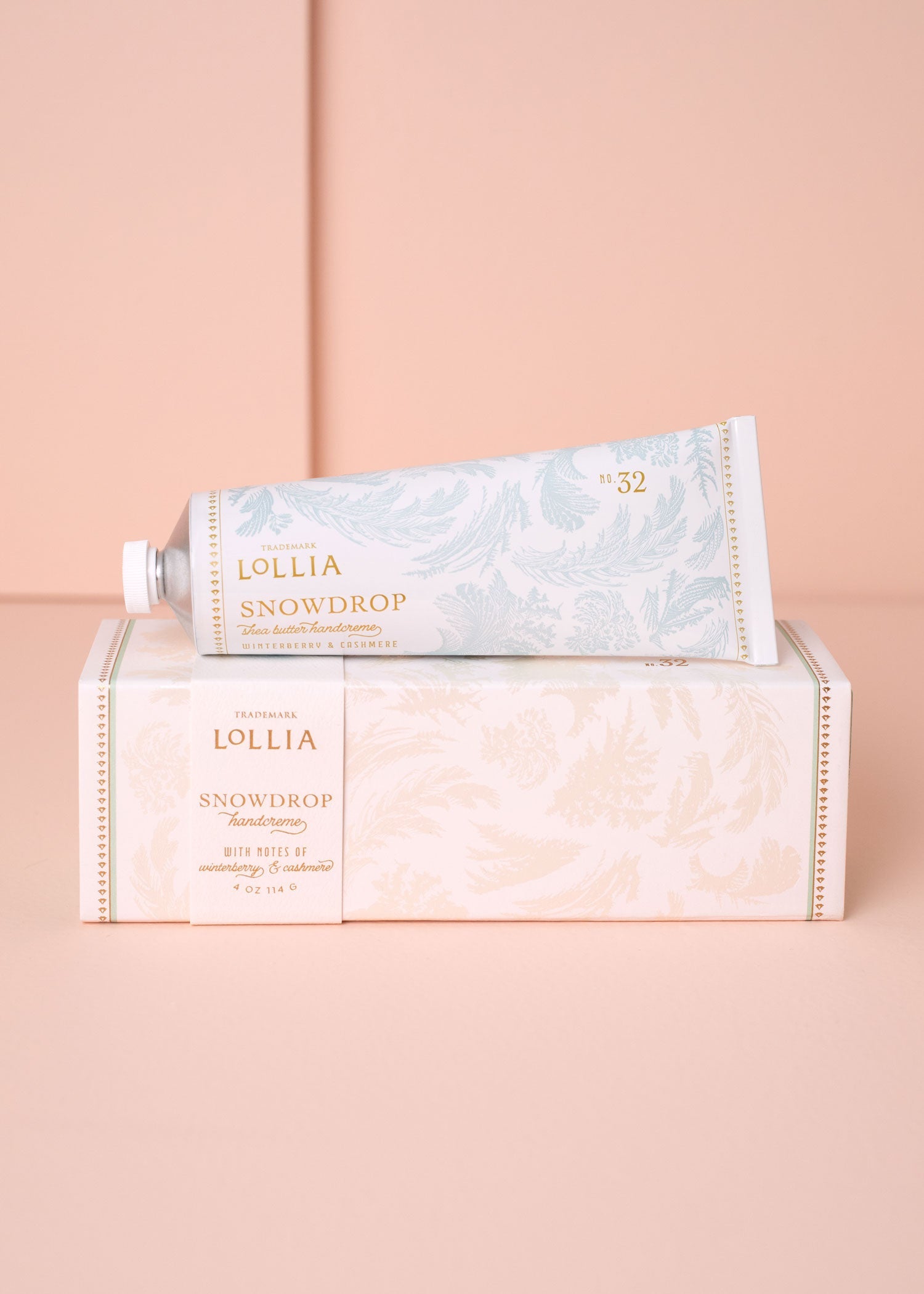 Lollia Snowdrop hand cream packaging on a pink background