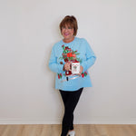 woman wearing a blue top against a white background. 