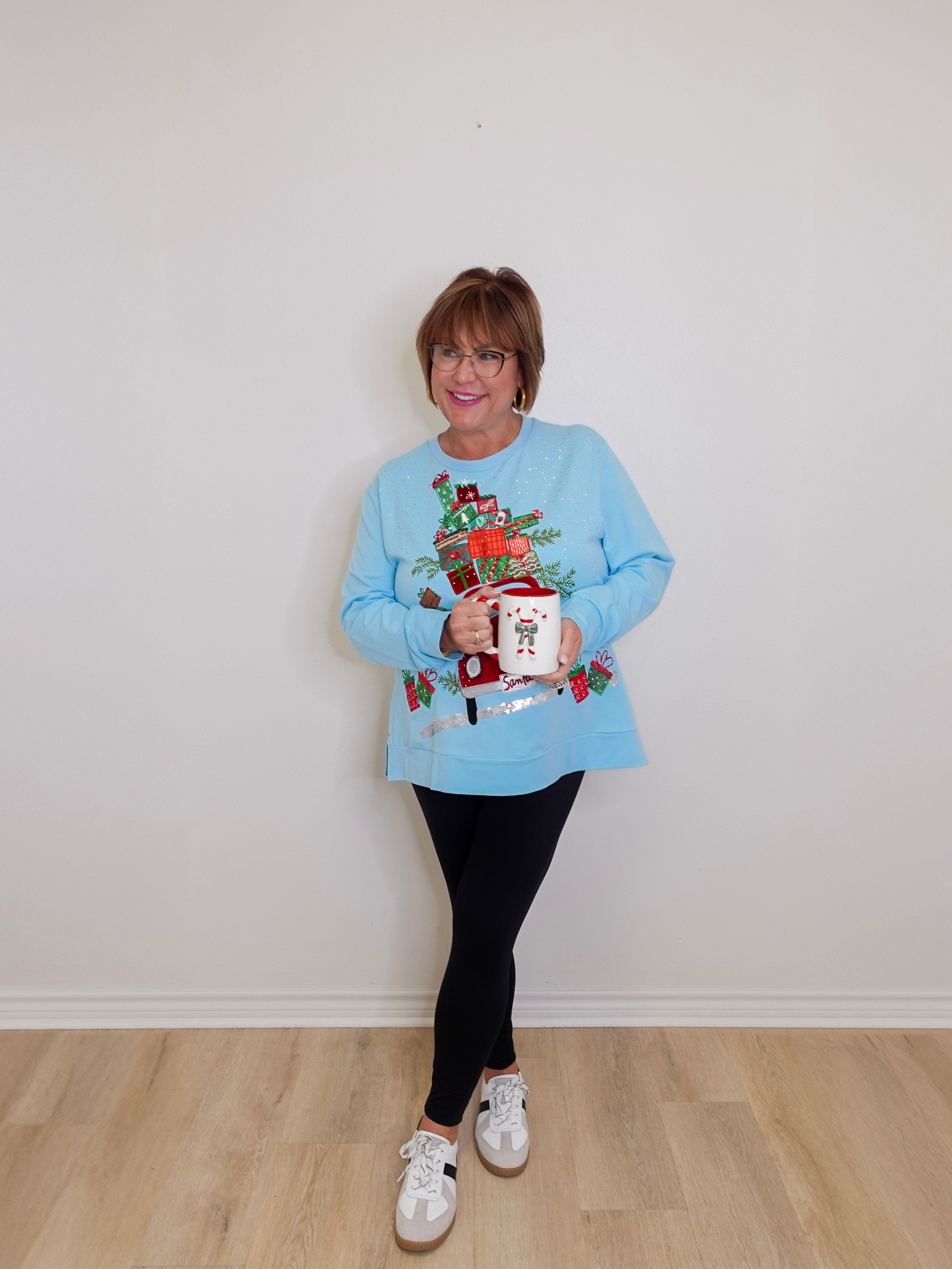 woman wearing a blue top against a white background. 