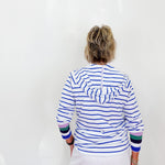 Person wearing a striped shirt with colorful cuffs and hem on a white background