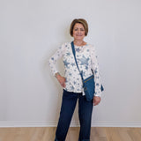 Woman wearing a star-patterned shirt and blue jeans with a white background