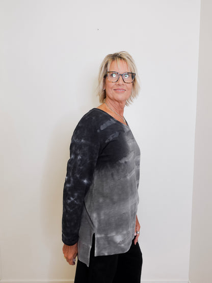 Person wearing a black and gray tie-dye long-sleeve shirt against a white background