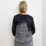 Person wearing a black and gray tie-dye long-sleeve shirt against a white background
