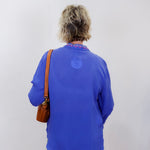 luisa shirt featuring blue fabric with pink and red embroidery worn by model