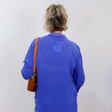 luisa shirt featuring blue fabric with pink and red embroidery worn by model