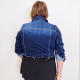 Person wearing a blue denim jacket against a white background