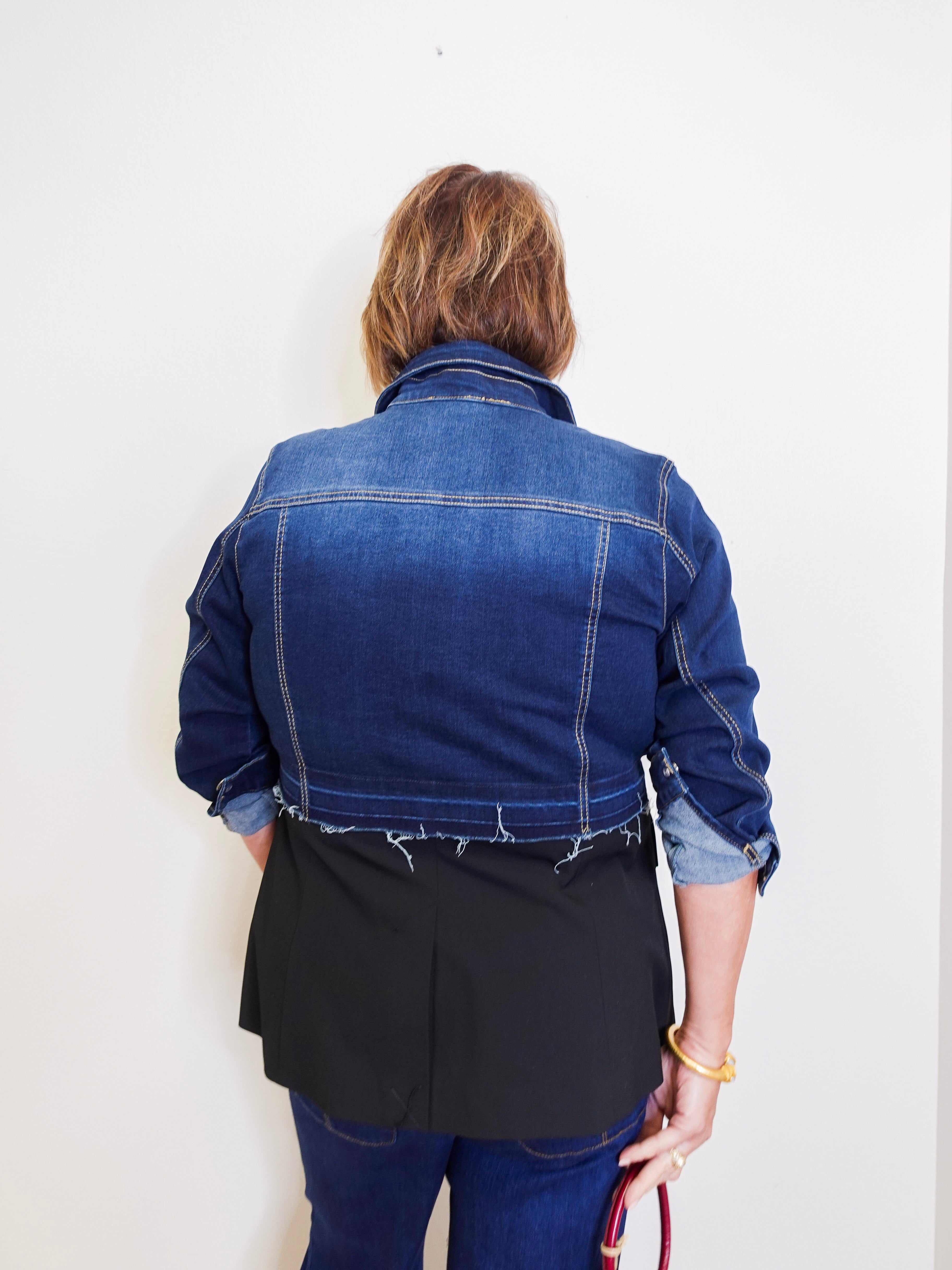 Person wearing a blue denim jacket against a white background