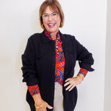Woman wearing a luxe shacked apny black women jacket in front a white background. 