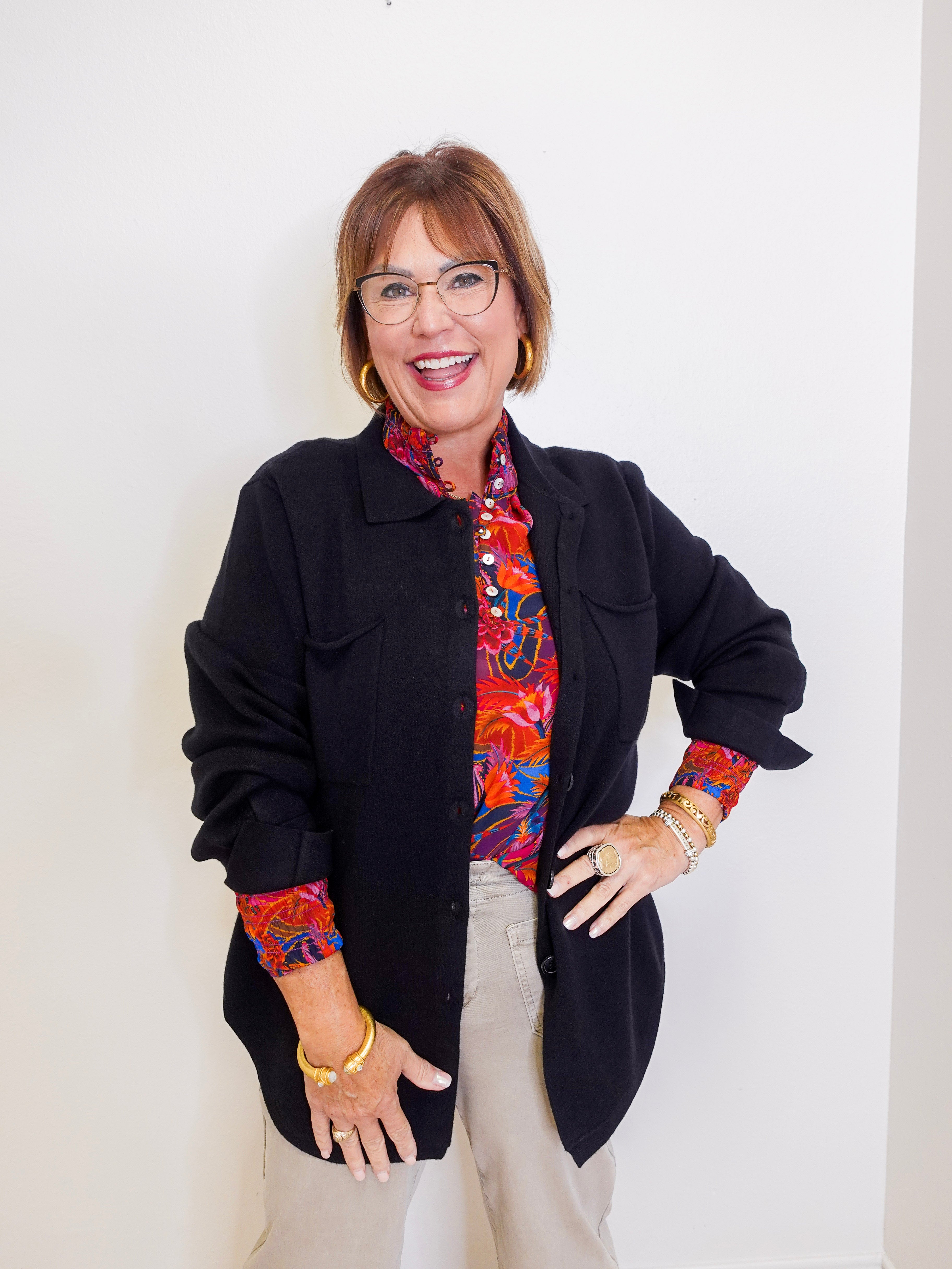 Woman wearing a luxe shacked apny black women jacket in front a white background. 