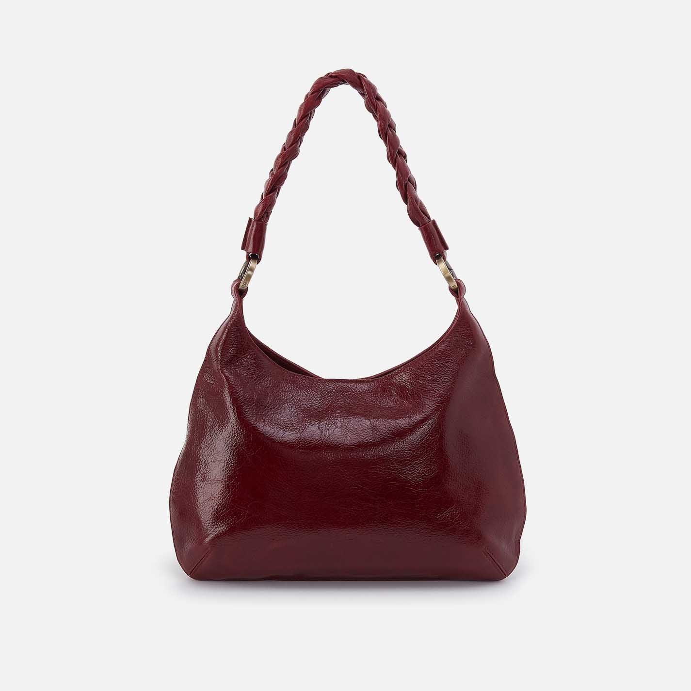Maroon handbag with braided handle on a light gray background