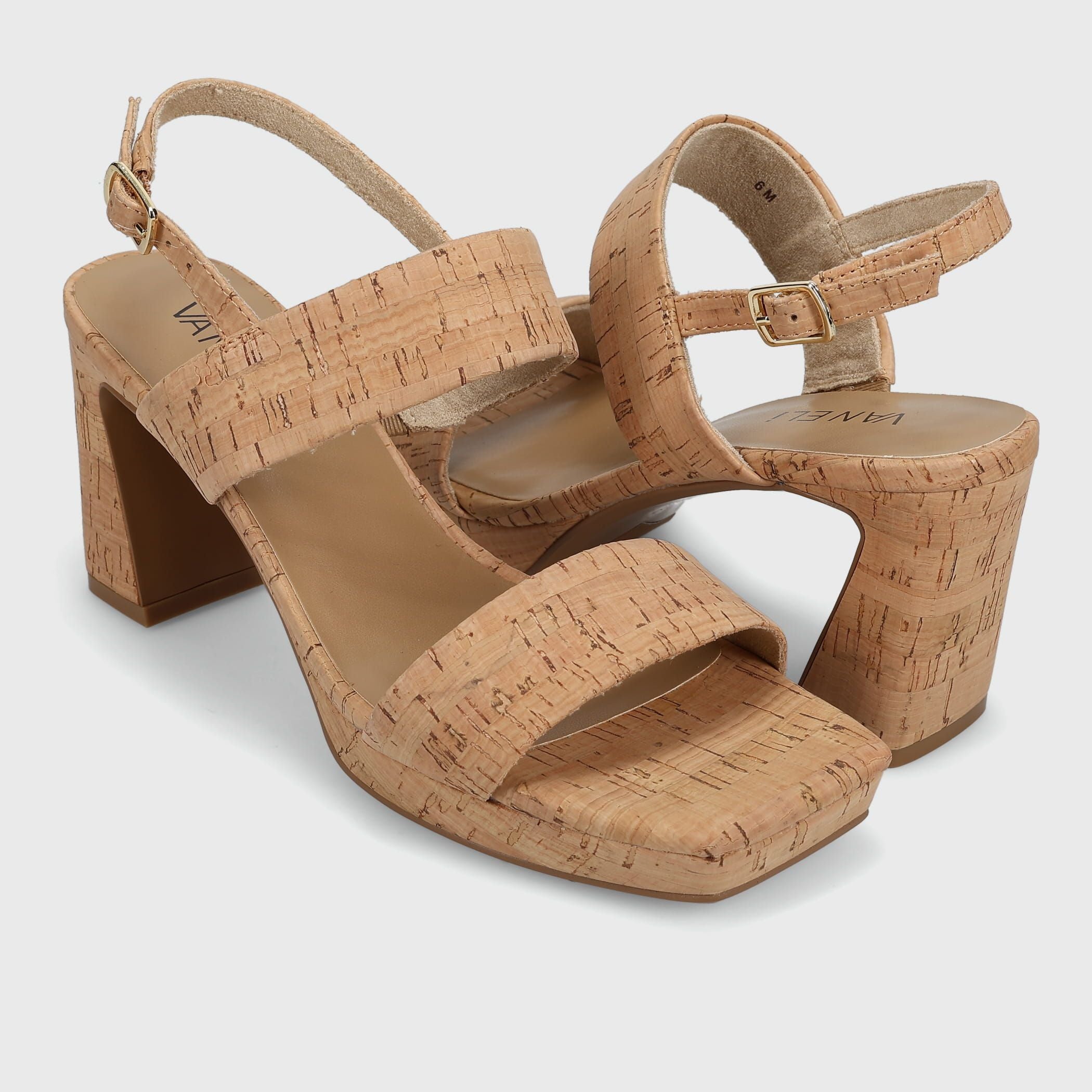 Pair of cork sandals with block heels on a light gray background