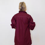 Person wearing a burgundy dress against a white background