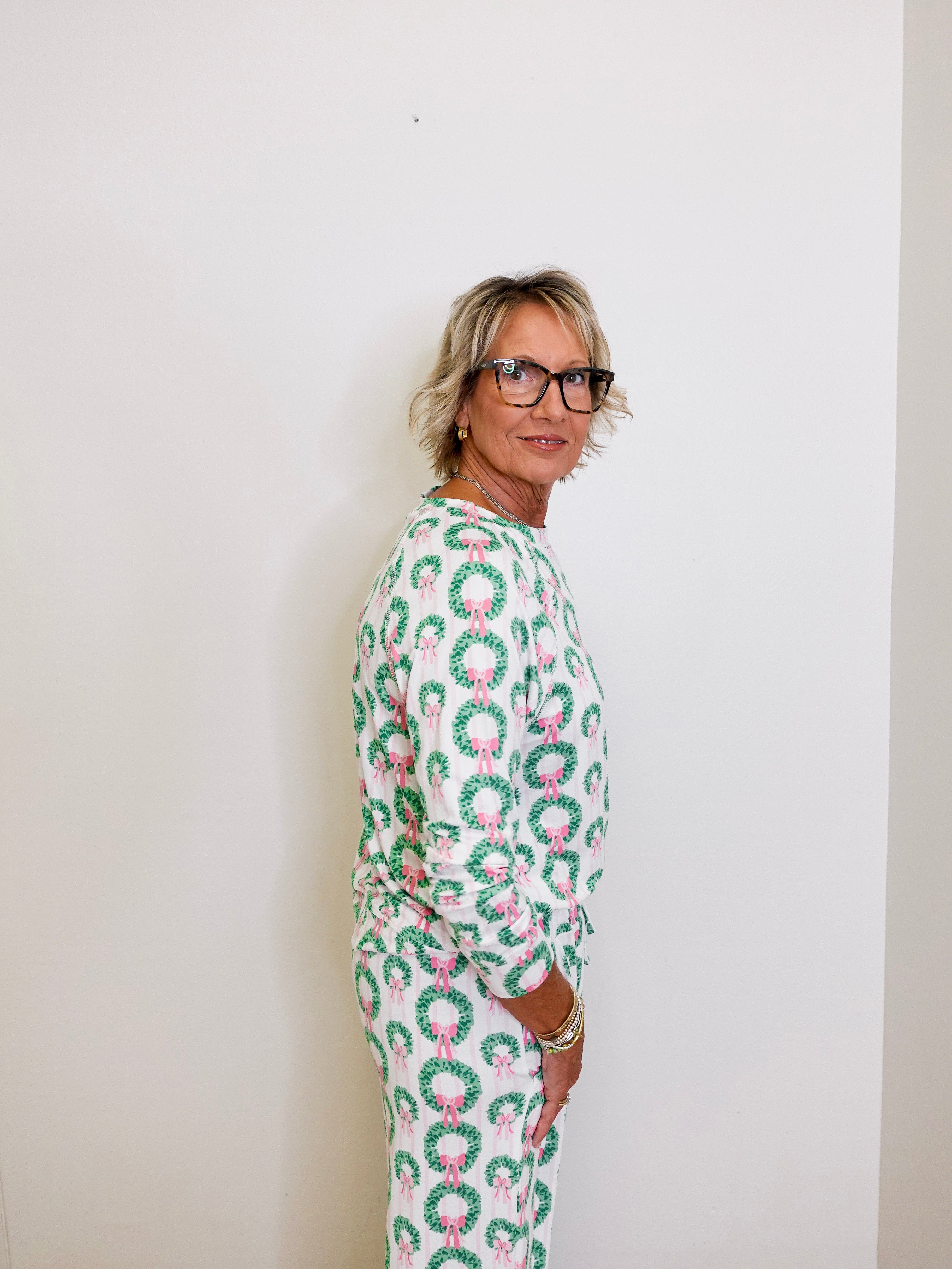 Person wearing a green and pink patterned outfit against a white background
