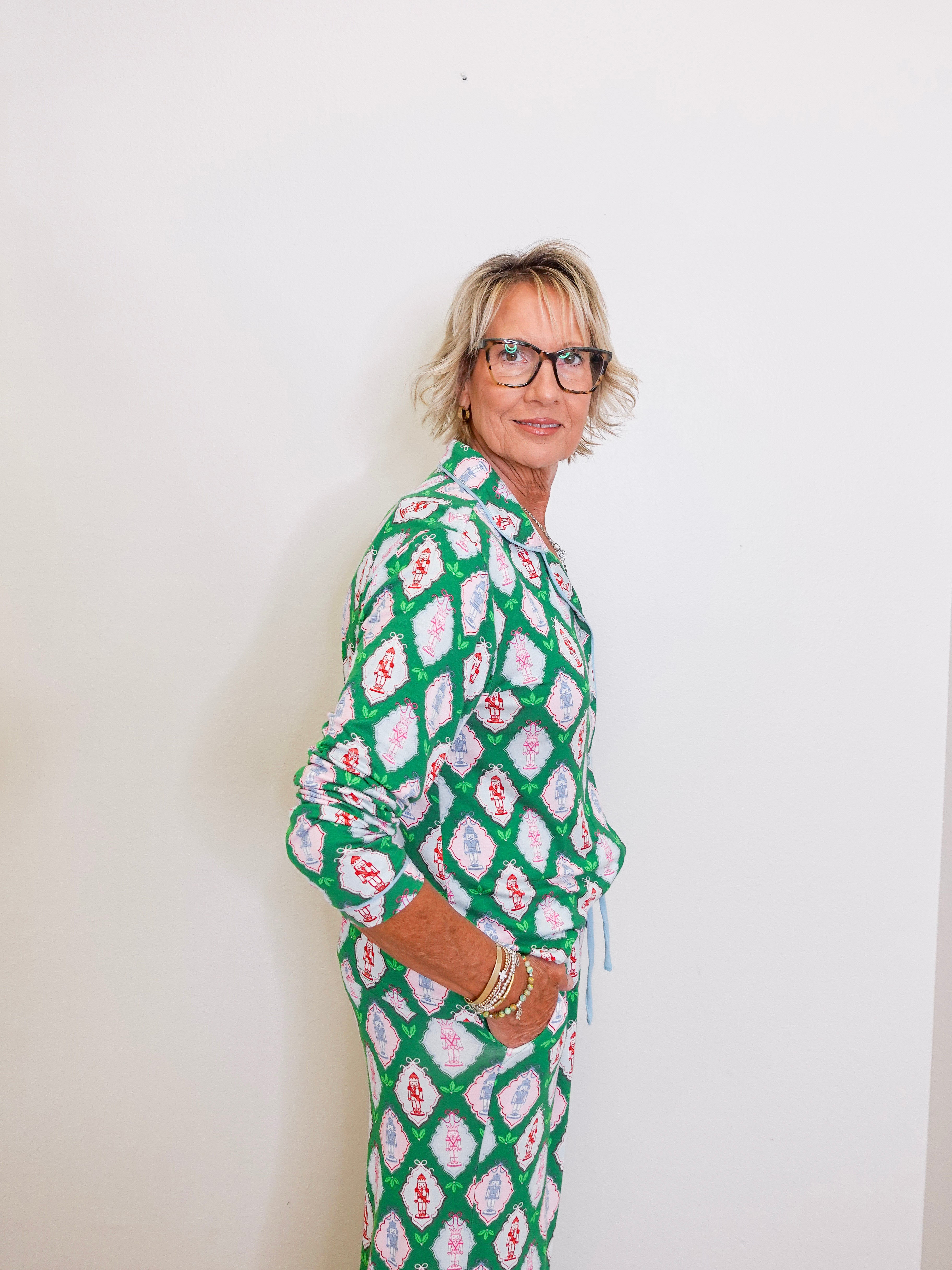 Woman wearing a green patterned outfit against a white background