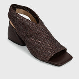 A dark brown woven slingback sandal with a square toe and low block heel, shown from a three-quarters angle on a light gray background.