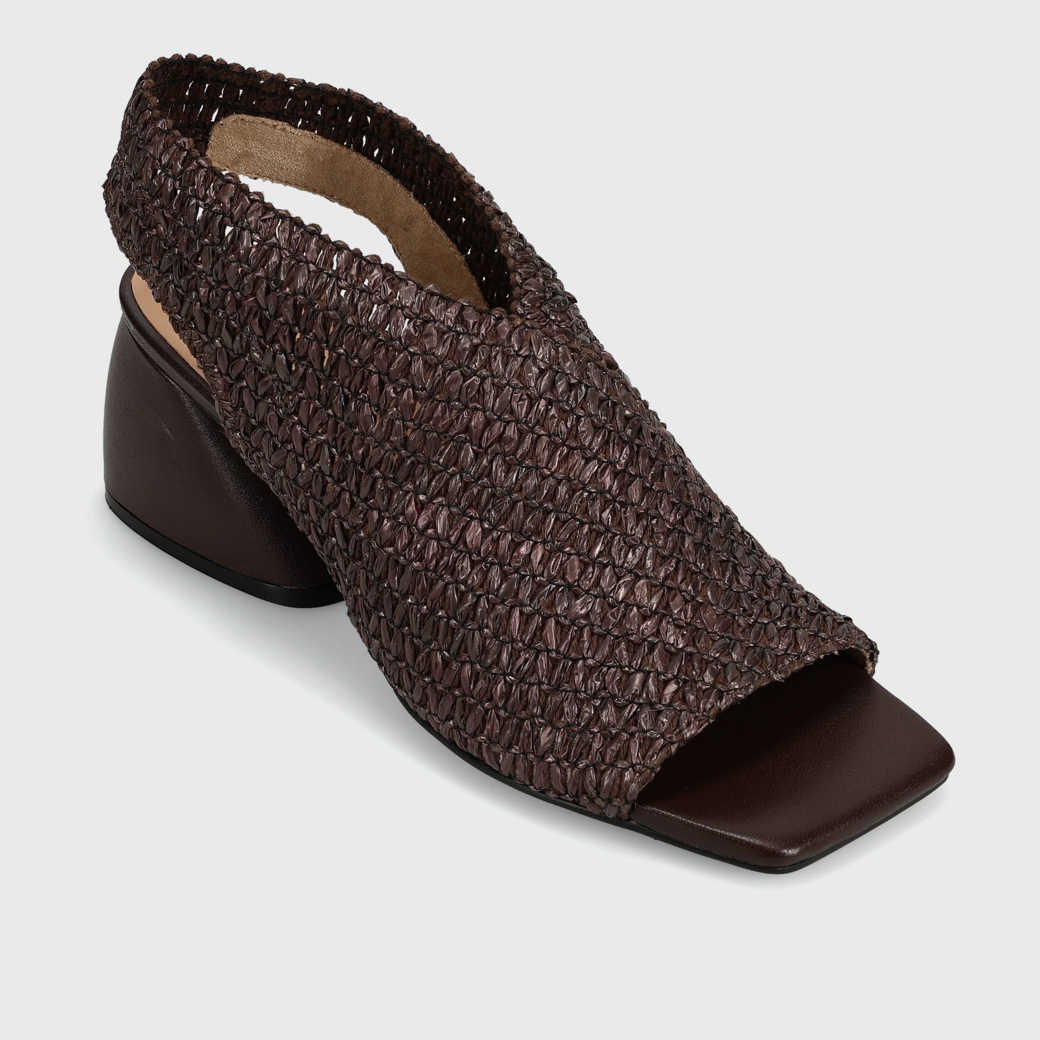 A dark brown woven slingback sandal with a square toe and low block heel, shown from a three-quarters angle on a light gray background.