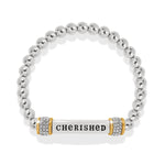 Silver beaded bracelet with a central bar engraved with 'CHERISHED' on a white background