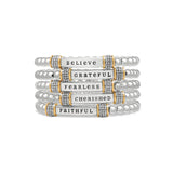 Stack of silver bracelets with motivational phrases on a white background