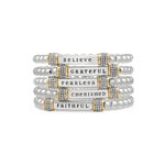 Stack of silver bracelets with motivational phrases on a white background