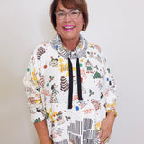 Woman wearing a colorful patterned sweater with a white background